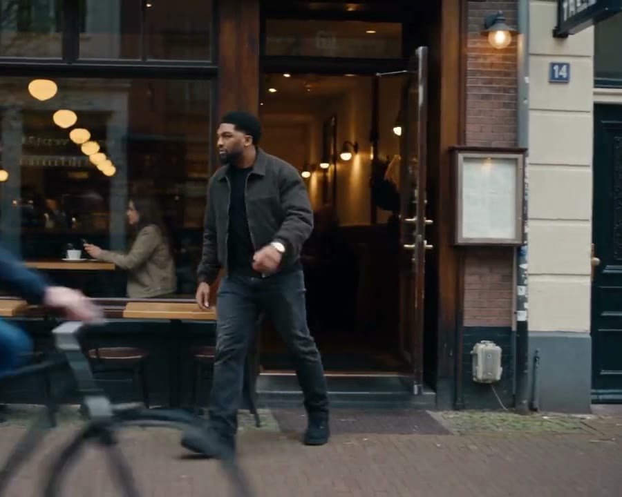 Josh walking a city street in a jacket, shot on location